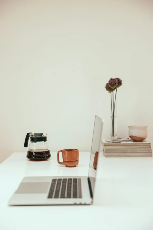 a laptop computer sitting on top of a white desk, a still life, unsplash, multiple stories, brown, morning haze, knickknacks