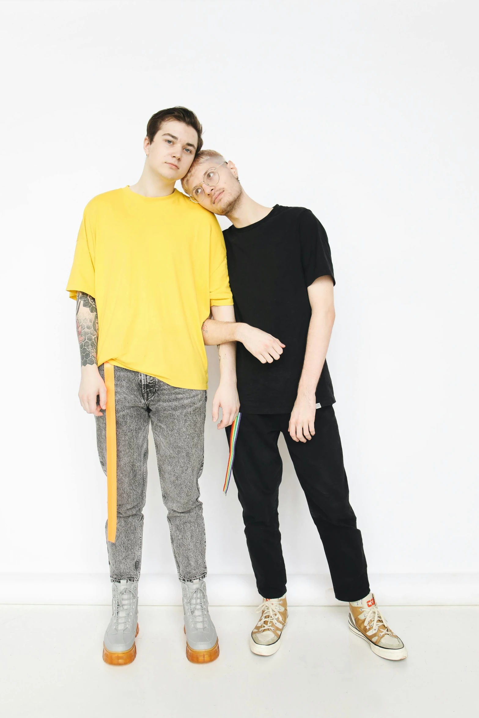 a man and a woman standing next to each other, unsplash, antipodeans, wearing a modern yellow tshirt, nonbinary model, edmund blair and charlie bowater, wearing pants