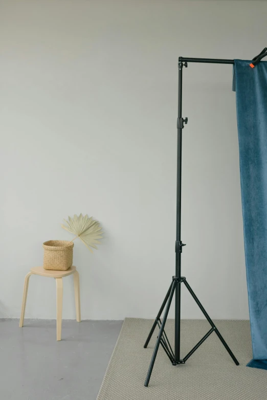 a photo studio with a blue curtain and a chair, a picture, unsplash, stand, beams, portrait n - 9, diverse