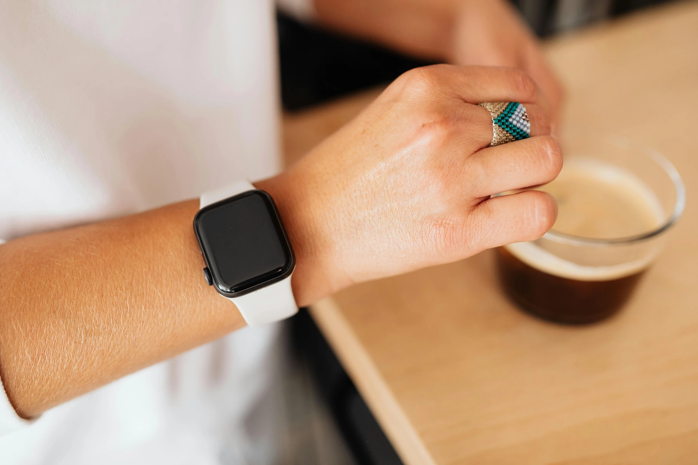 a close up of a person holding a cup of coffee, inspired by Eero Snellman, wears a watch, apple, square, sitting in a cafe