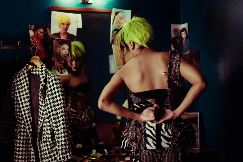 a woman with bright green hair standing in front of a mirror, inspired by Elsa Bleda, maximalism, bare back, wearing disco suit, woman holding another woman, filmstill