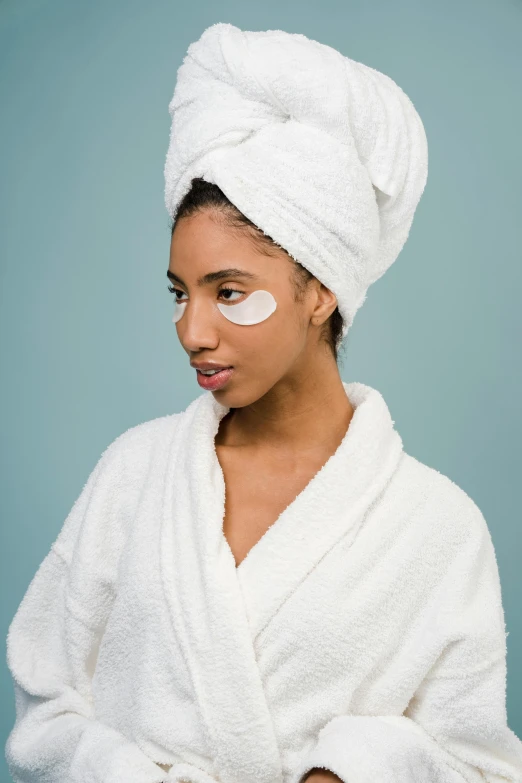 a woman with a towel wrapped around her head, trending on pexels, renaissance, black eye patch over left eye, aida muluneh, wearing long white robe, cosmetics