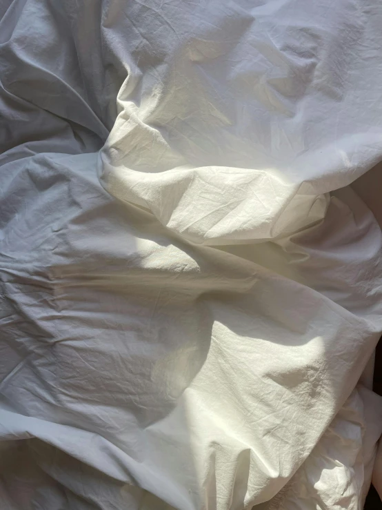 an unmade bed with white sheets and a teddy bear, by Rebecca Horn, visual art, iphone photo, overhead sun, 62 x 47 inches, detail shot