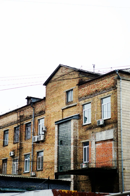 a truck that is parked in front of a building, unsplash, socialist realism, low quality photo, chimneys on buildings, machinery and wires, old brick walls