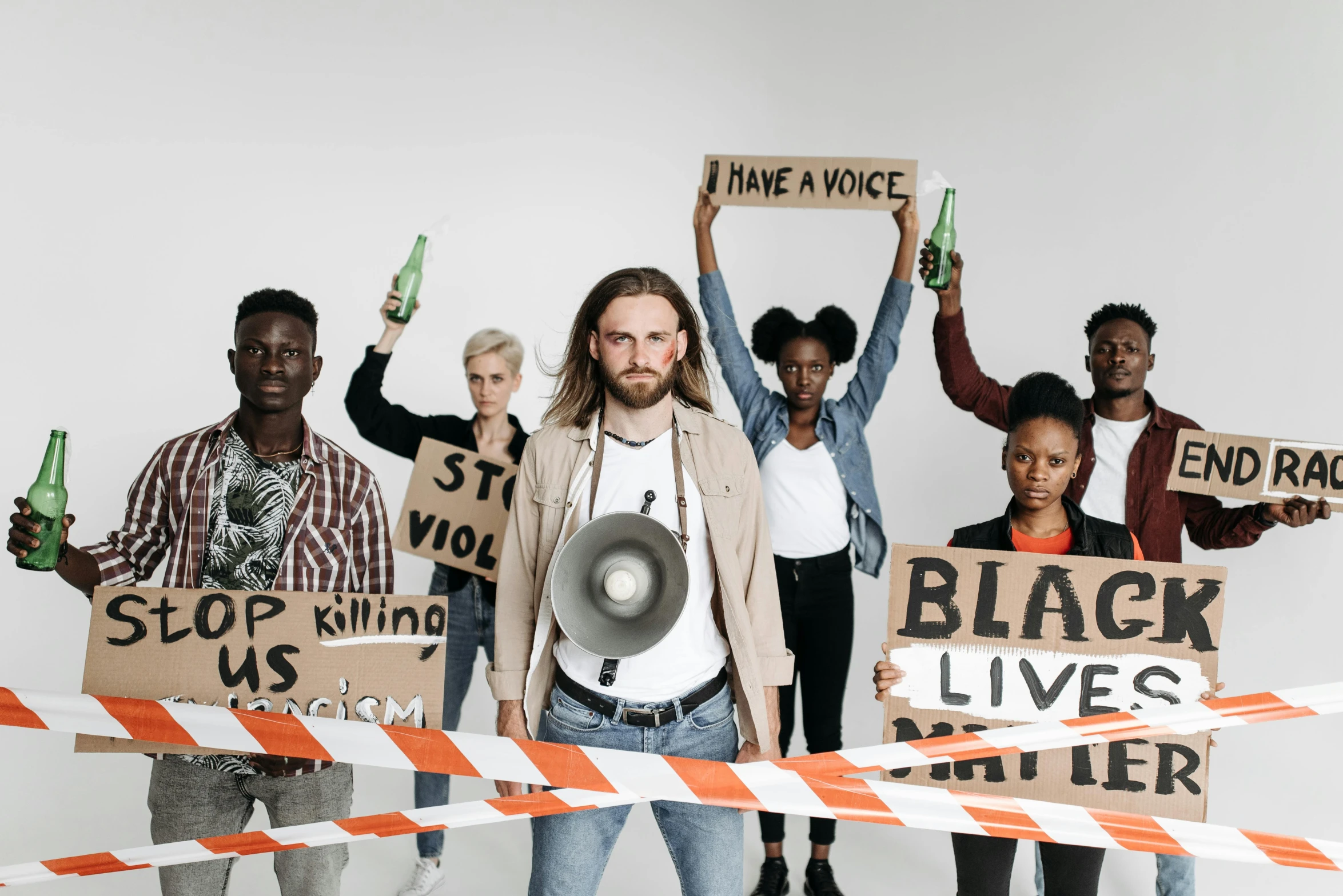 a group of people holding signs and a megaphone, a photo, by Matija Jama, trending on pexels, man is with black skin, background image, bandoliers, cardboard cutout