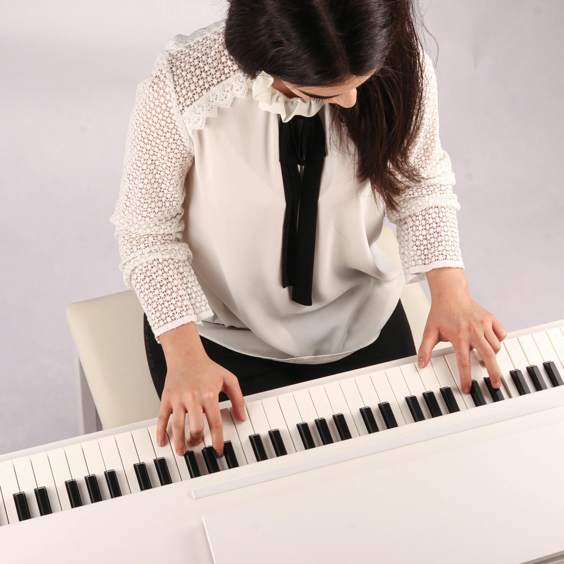 a woman in a white shirt is playing the piano, inspired by Kawai Gyokudō, mechanical keyboard, with a white background, student, wide overhead shot