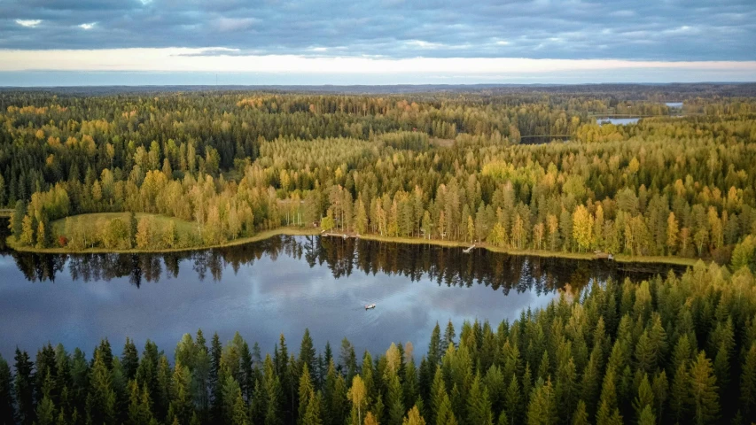 a large body of water surrounded by trees, by Jaakko Mattila, pexels contest winner, hurufiyya, forest in the background, air shot, thumbnail, camp