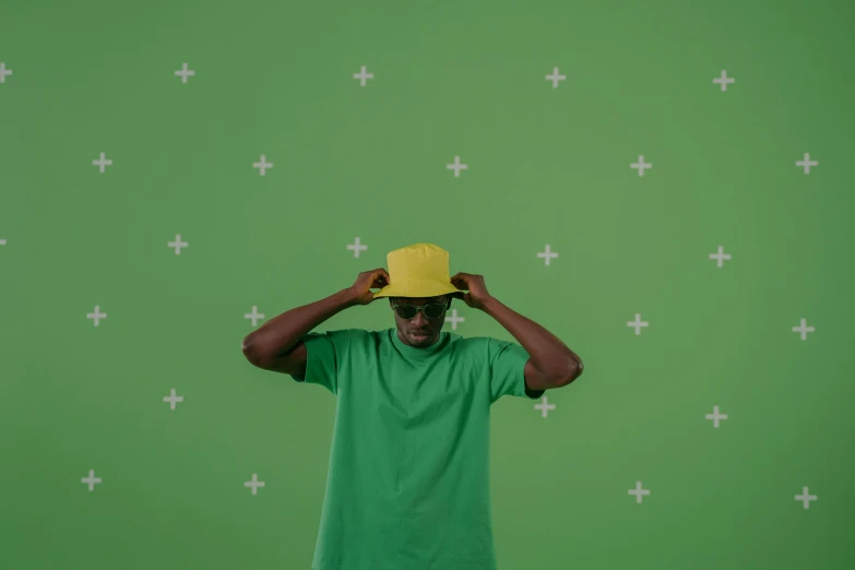 a man in a green shirt and a yellow hat, pexels contest winner, ( ( dark skin ) ), clean background trending, vfx shot, background(solid)