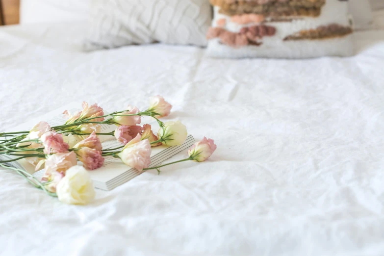 a piece of cake sitting on top of a bed, by Alice Mason, romanticism, polished white marble, professional product photo, flower decorations, un made bed