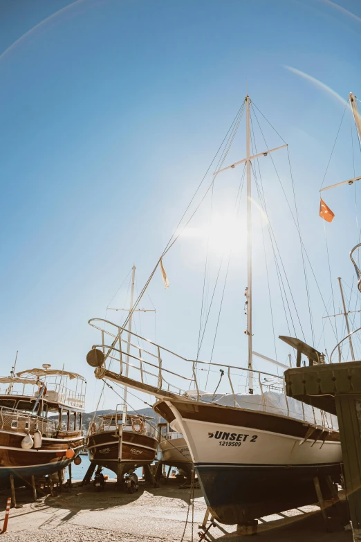 a couple of boats sitting on top of a sandy beach, sun flares, on the deck of a sailing ship, istanbul, today\'s featured photograph 4k