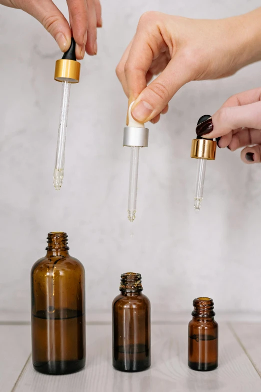 a group of people holding bottles of essential oils, by Julia Pishtar, metal handles, thumbnail, transparent
