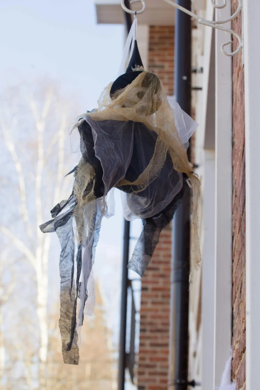 a couple of bags hanging from the side of a building, photo of a ghostly pirate, wrapped in a black scarf, slide show, full res