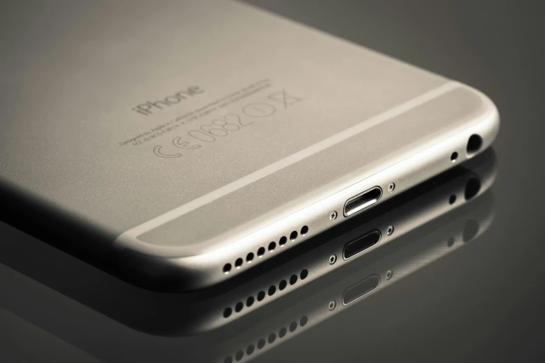 a silver iphone sitting on top of a table, pexels, photorealism, side view intricate details, close - up profile, backlighted, aluminum