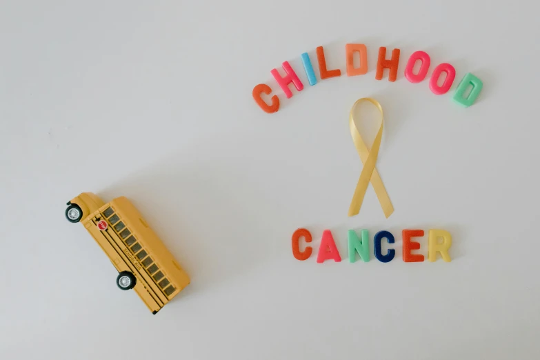a school bus next to a sign that says childhood cancer, pexels contest winner, profile image, ribbon, cheerios, 90s photo
