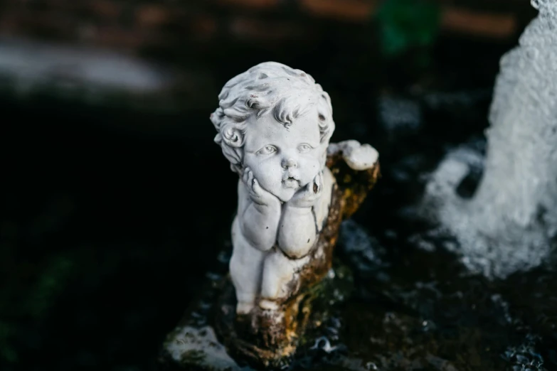 a statue of a child sitting on top of a fountain, inspired by Correggio, unsplash, porcelain white face, high quality product image”, on a branch, occasional small rubble