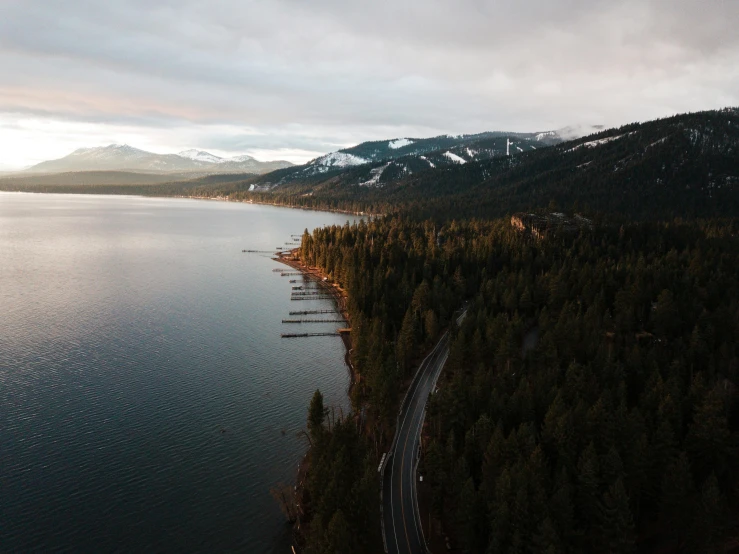 a large body of water next to a forest, by Marshall Arisman, pexels contest winner, highway 5 0, evergreen valley, split near the left, computer wallpaper