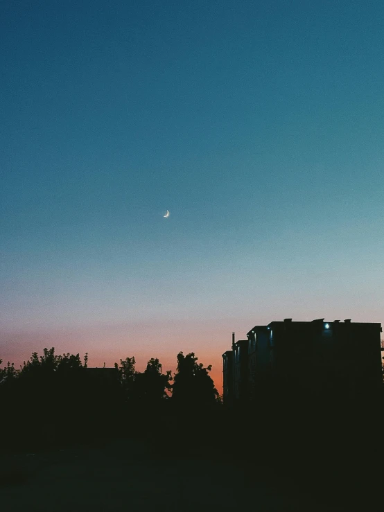 a couple of buildings sitting next to each other, inspired by Elsa Bleda, unsplash contest winner, postminimalism, shining crescent moon, late summer evening, view from afar, trending on vsco