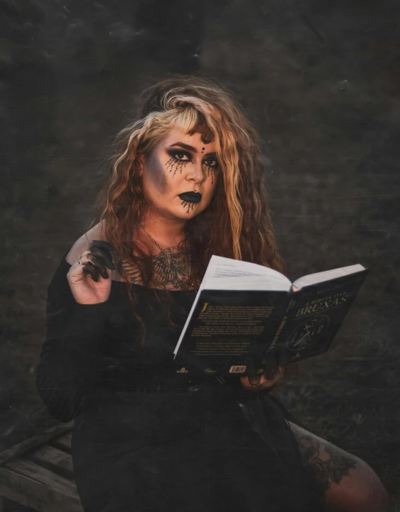 a woman sitting on a bench reading a book, an album cover, pexels contest winner, gothic art, prosthetic makeup, necronomicon, ☁🌪🌙👩🏾, grunged up