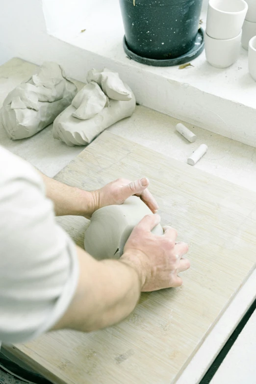 a person is making a bowl out of clay, a marble sculpture, inspired by Sarah Lucas, face down, multi-part