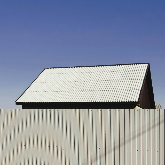 a red fire hydrant sitting in front of a building, an album cover, by David Simpson, postminimalism, metal cladding wall, desert white greenhouse, shot from roofline, shed