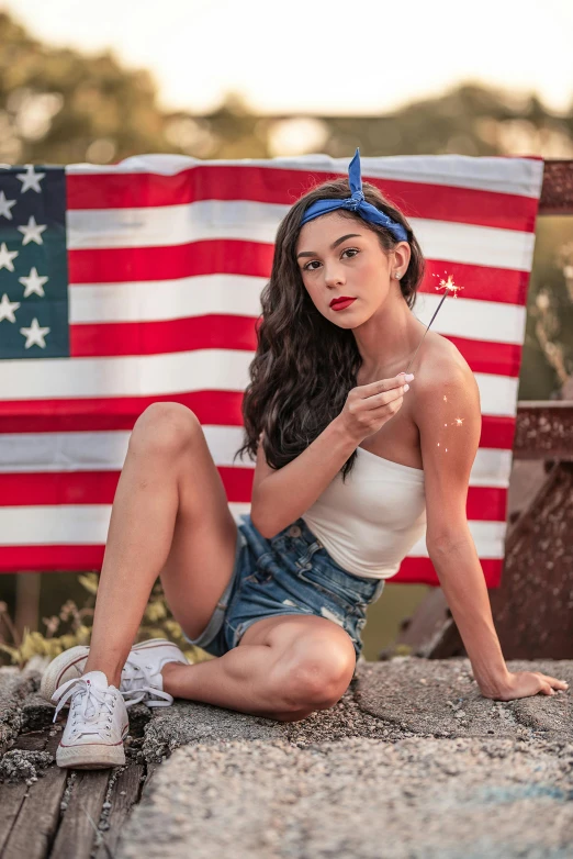 a woman sitting on the ground in front of an american flag, a portrait, pexels contest winner, madison beer girl portrait, uncle sam, daisy dukes, morena baccarin