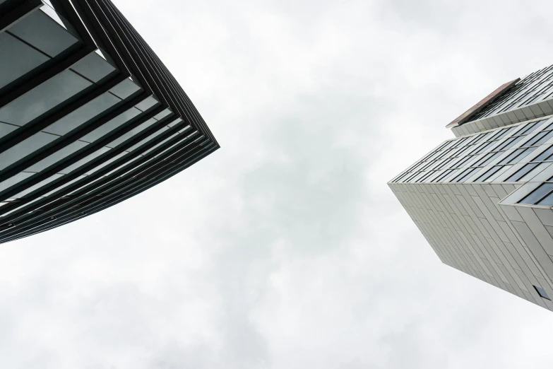 a couple of tall buildings next to each other, a photo, pexels contest winner, minimalism, white sky, face looking skyward, big overcast, square lines