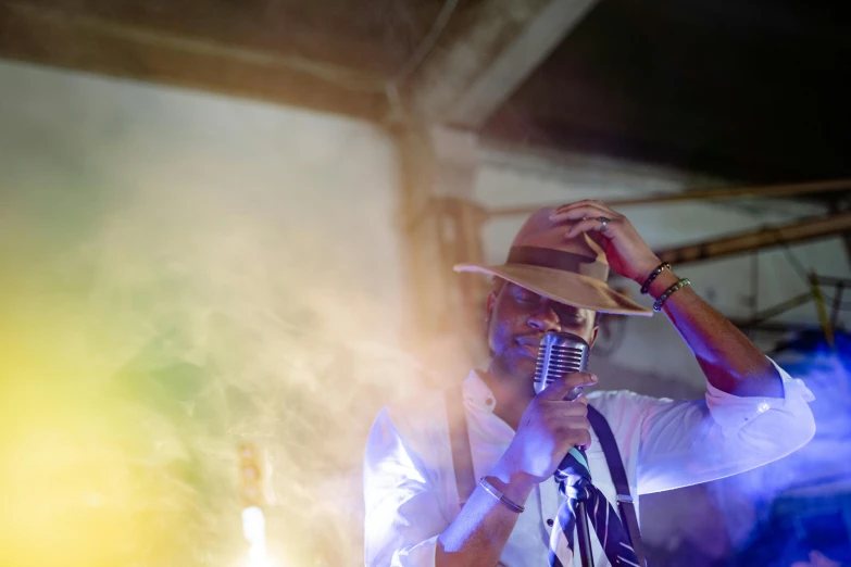 a man in a hat singing into a microphone, by Daniel Lieske, unsplash, happening, shpongle, light haze, wedding, rectangle