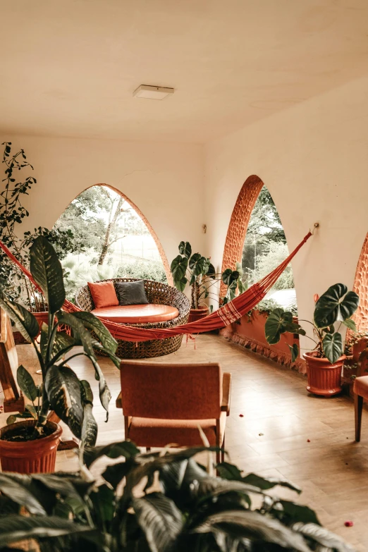 a living room filled with lots of furniture and plants, by Tobias Stimmer, pexels contest winner, curving geometric arches, health spa and meditation center, colombian, comfy chairs