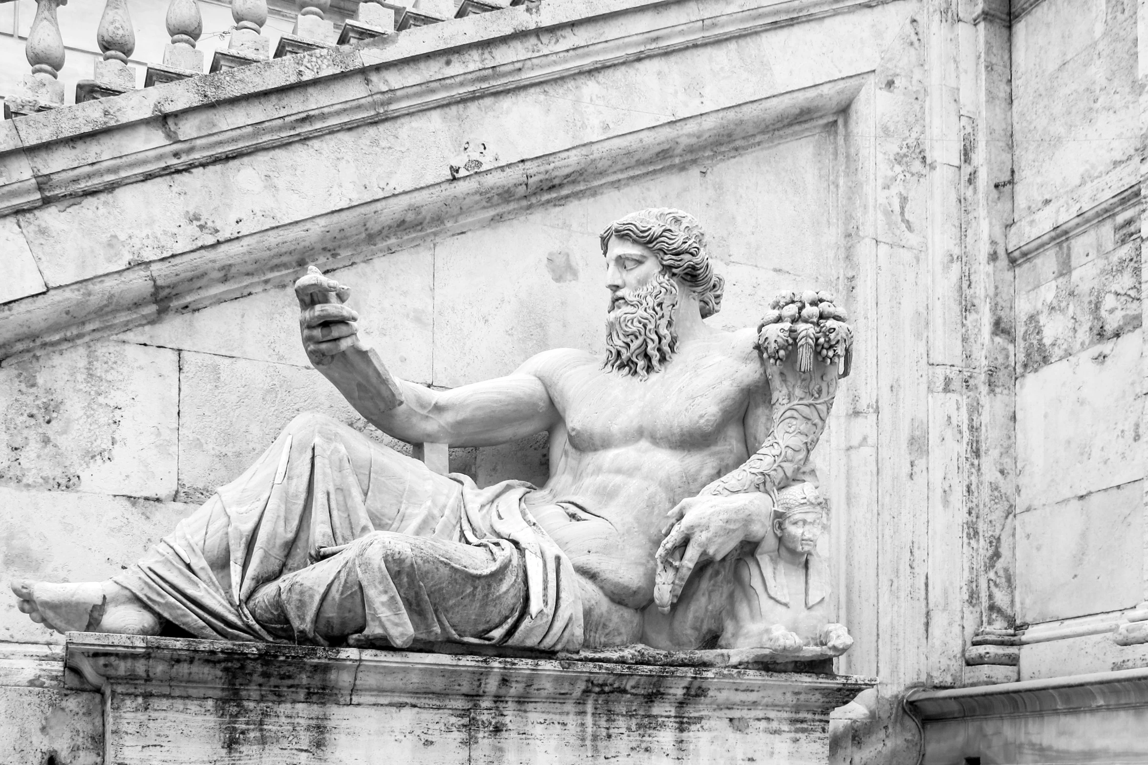 a statue of a man sitting on top of a building, a marble sculpture, by Francesco Filippini, old gods, with a cool pose, ancient rome, the greek god of wine