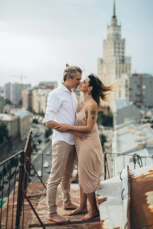 a man and a woman standing on top of a building, a photo, mucha and artem demura, city views, male and female, celebrating