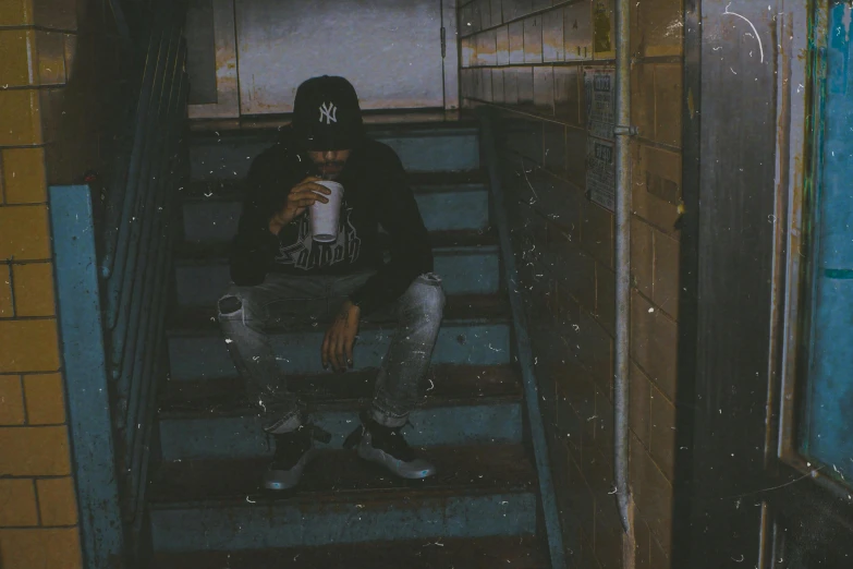 a man that is sitting down on some stairs, an album cover, inspired by Elsa Bleda, unsplash, graffiti, coffee cup, low quality photo, grime, long night cap