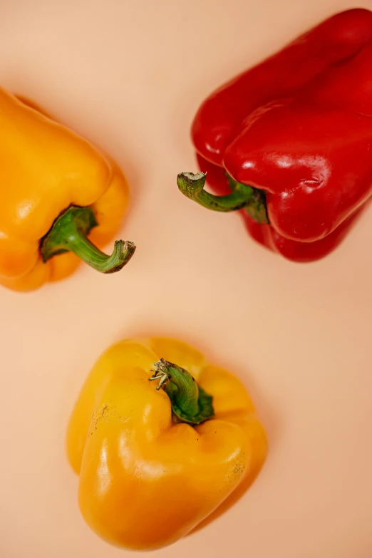 three peppers sitting next to each other on a table, trending on pexels, warm color, detailed product image, plain background, full product shot