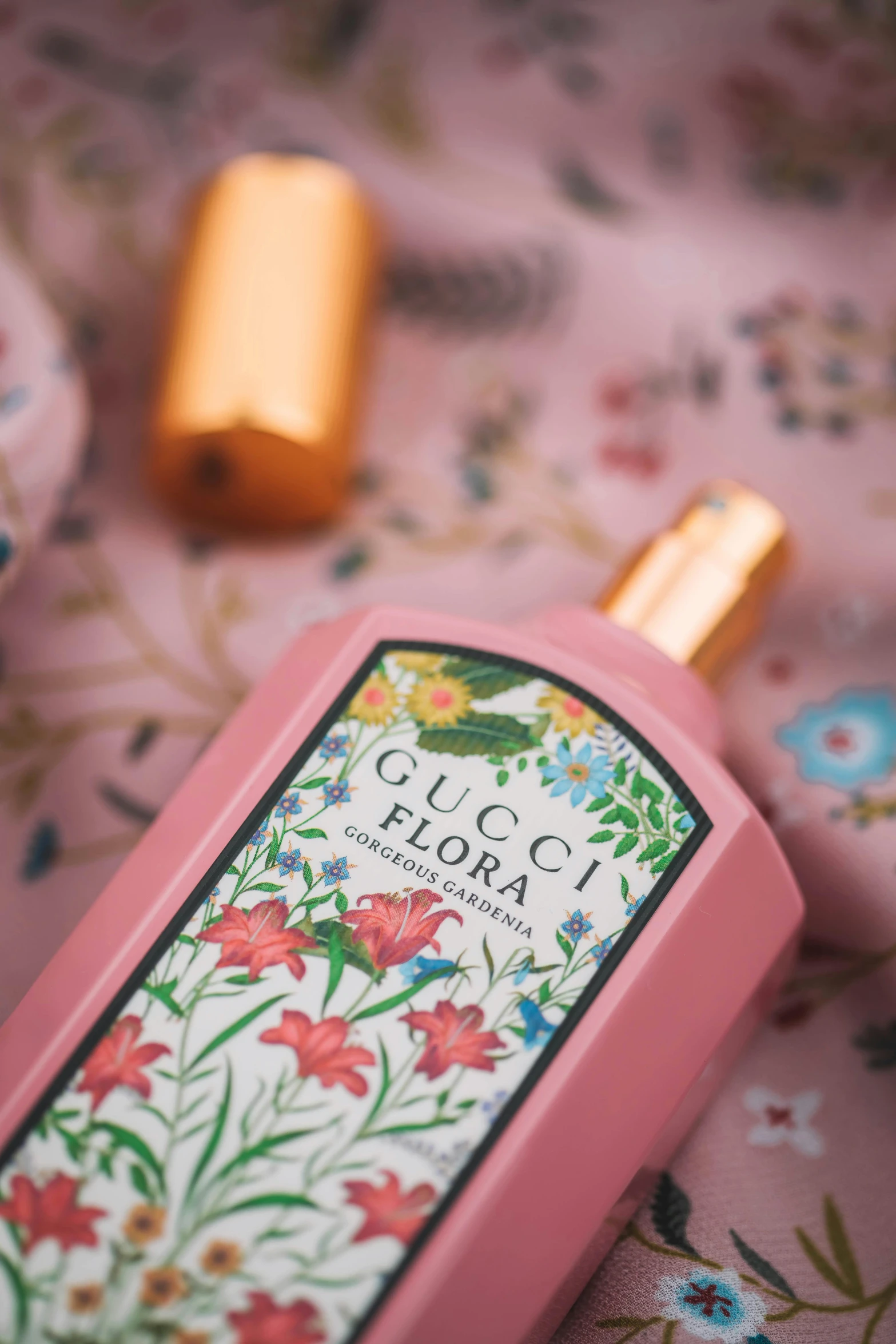 a bottle of perfume sitting on top of a bed, a picture, wearing pink floral chiton, gucci poster, product label, flora and fauna