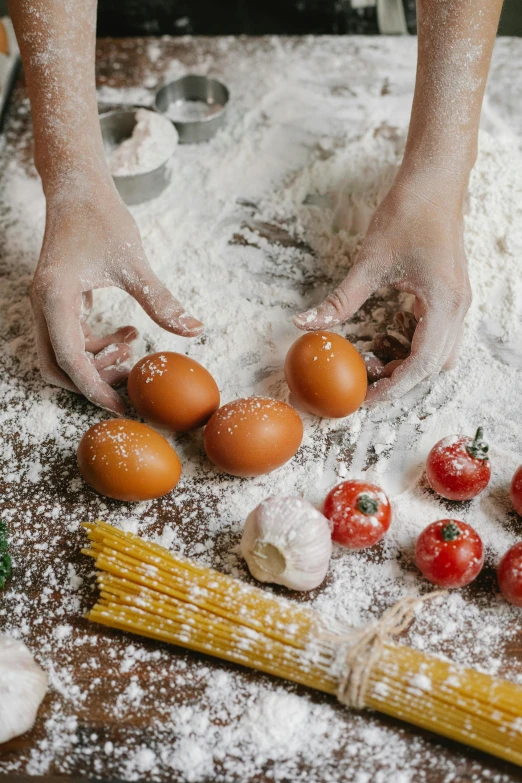 a close up of a person preparing food on a table, covered in white flour, eggs, tomatoes, background image