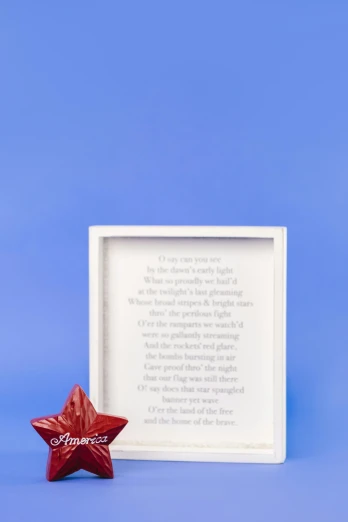 a red star next to a white frame on a blue background, inspired by Khalil Gibran, home display, poetry, full product shot, studio photo of a ceramic figure