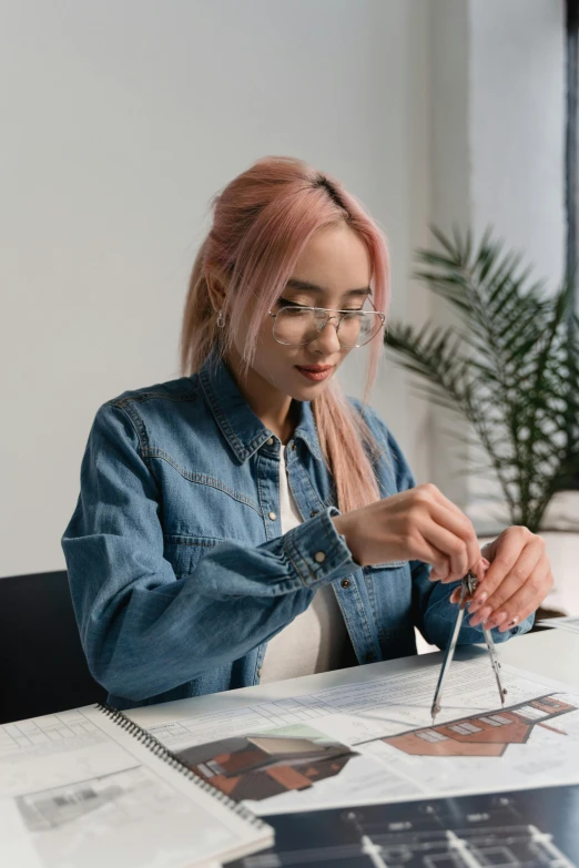 a woman sitting at a table in front of a laptop, an airbrush painting, inspired by Ruth Jên, trending on pexels, square rimmed glasses, architect, wearing denim, gif