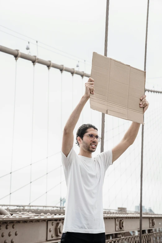 a man holding up a sign on top of a bridge, pexels contest winner, renaissance, made of cardboard, brooklyn, excited, but minimalist