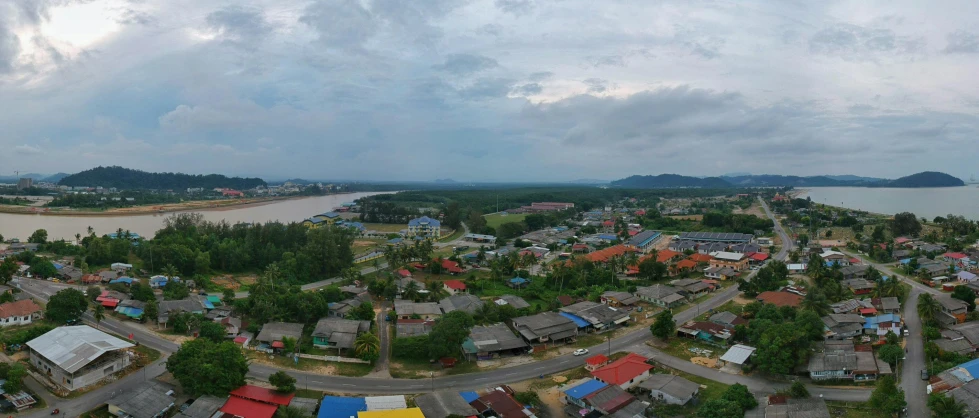 a bird's eye view of a town next to a body of water, a picture, hurufiyya, gopro photo, malaysian, ultrawide lens”, slight overcast