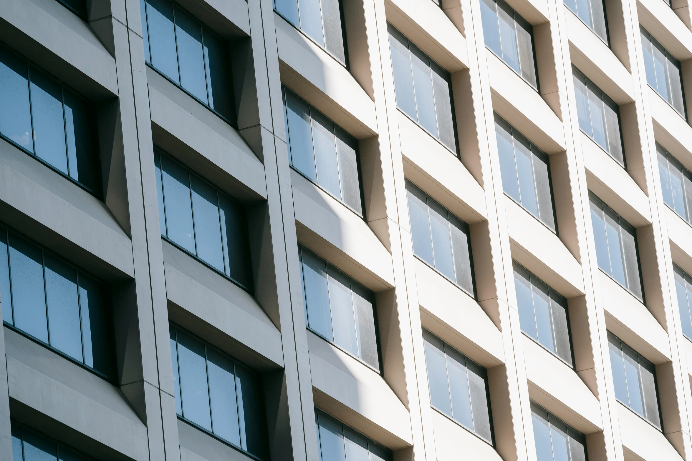 a clock mounted to the side of a tall building, inspired by David Chipperfield, unsplash, brutalism, sunlit windows, arasaka, 2000s photo, square lines