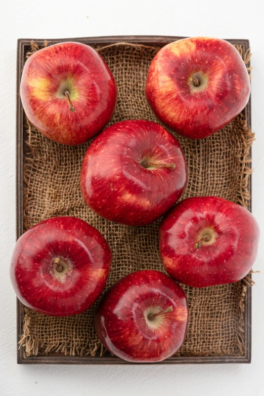 a box filled with red apples sitting on top of a table, full product shot, crimson, 6 pack, no foliage