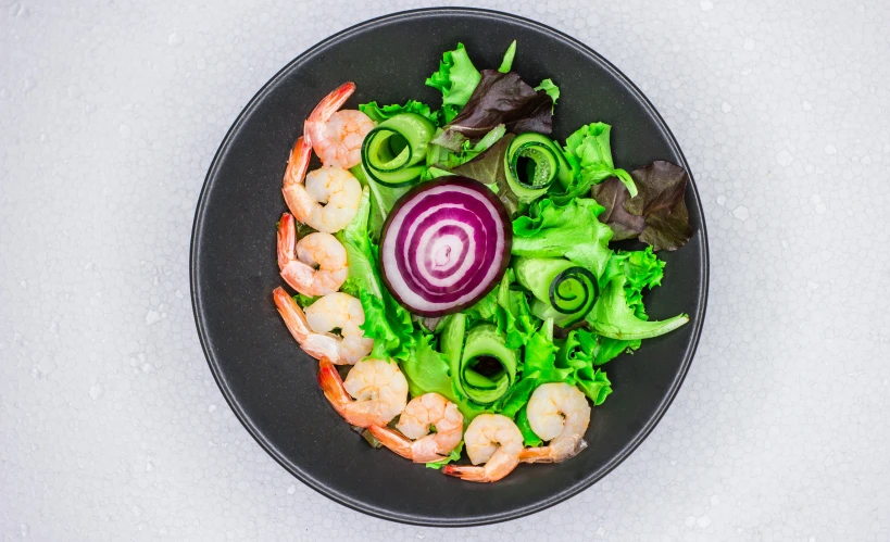 a black plate topped with shrimp and lettuce, a digital rendering, unsplash, pink white and green, spiraling, professional product photo, bowl