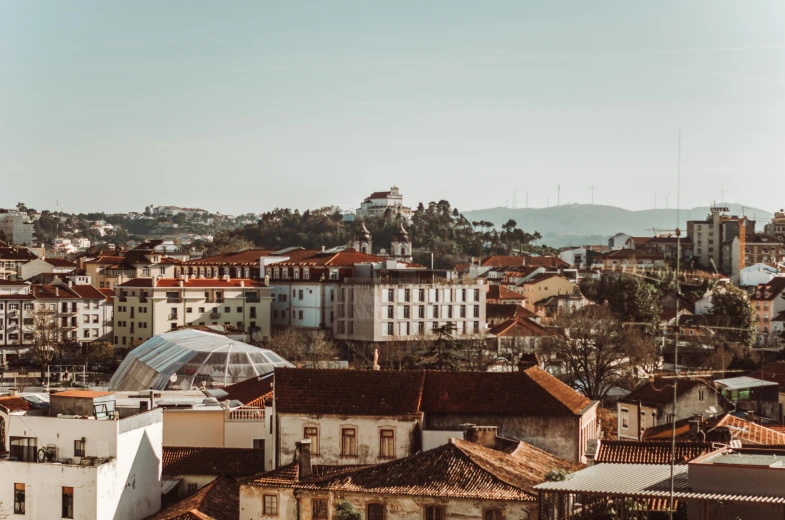 a view of a city from the top of a building, a photo, by Emma Andijewska, pexels contest winner, renaissance, gui guimaraes, hills in the background, clear and sunny, square