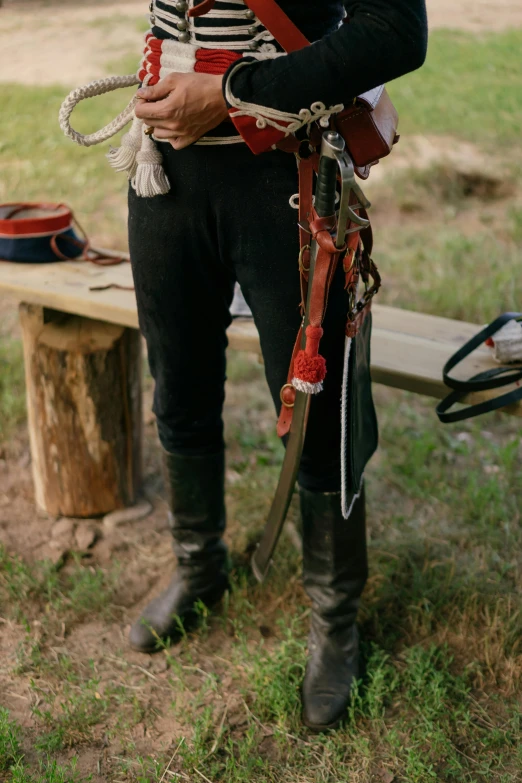 a man in a pirate costume standing next to a bench, trending on unsplash, wide belt scabbard, custer's last stand, up close image, camp