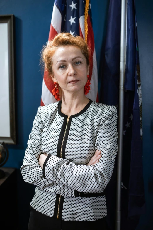 a woman standing in front of an american flag, inspired by Nil Gleyen, redhead woman, official government photo, mircea suciu, in the office