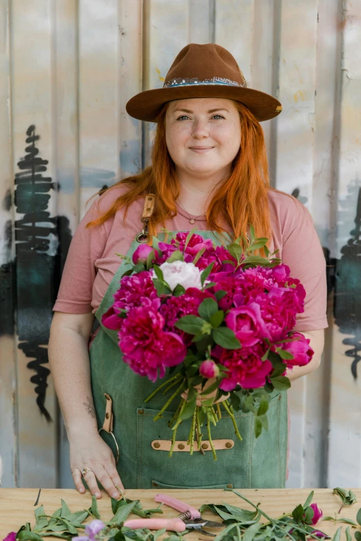 a woman in a hat holding a bouquet of flowers, wearing farm clothes, vibrantly lush, hr ginger, peonies