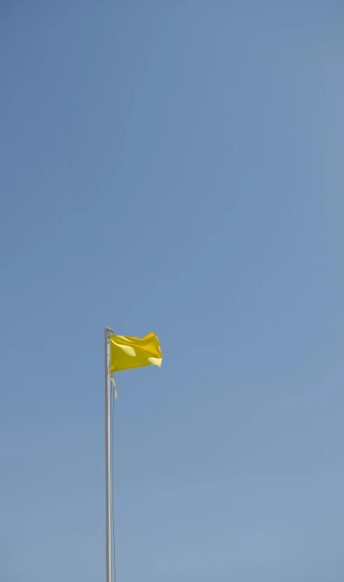 a yellow flag is flying high in the sky, by Matthias Stom, minimalism, dezeen, square, cloudless-crear-sky, india
