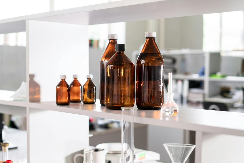 a number of bottles on a shelf in a room, a picture, lab in the background, brown, lumi, modular