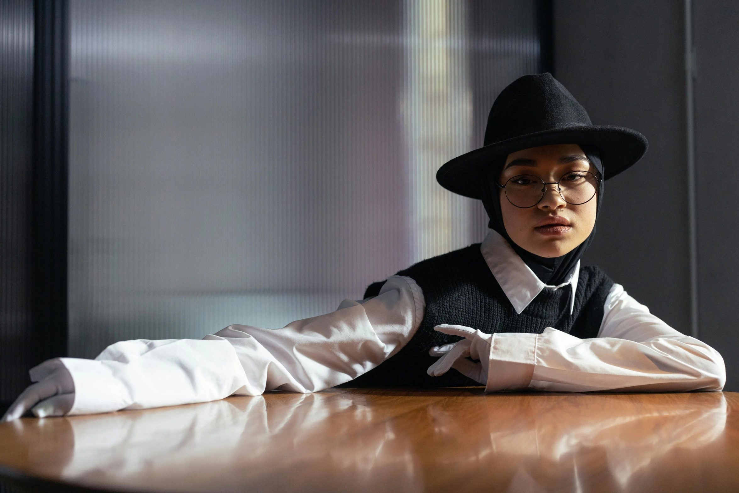 a person sitting at a table with a hat on, an album cover, inspired by Zhu Da, unsplash, hyperrealism, muslim, female lawyer, attractive androgynous humanoid, confident pose