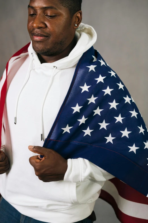 a man in a white hoodie holding an american flag, an album cover, by Samuel Washington Weis, pexels, hyperrealism, red and blue garments, close up high detailed, man wearing a closed cowl, plus-sized