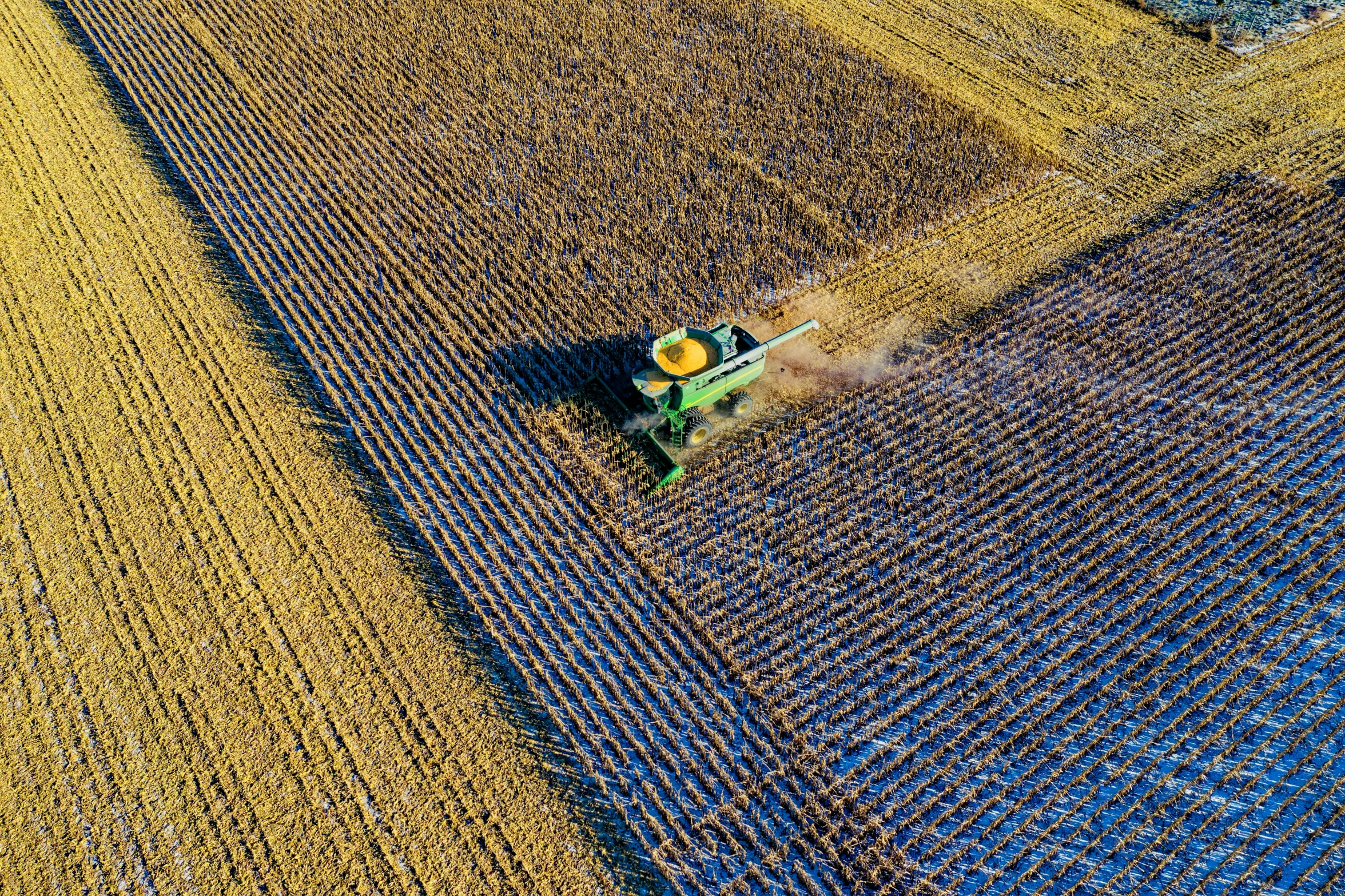 an aerial view of a tractor plowing a field, by Harvey Pratt, pexels, precisionism, 1024x1024, some yellow green and blue, corn, fine art print